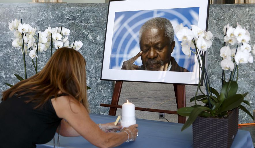 An UN staff member puts a candle in front of portrait of former United Nations Secretary General Kofi Annan prior to a ceremony of UN staff to pay tribute to Kofi Annan, at the &#x27;Salle des Pas Perdu&#x27; in the European headquarters of the United Nations in Geneva, Switzerland, Monday, Aug. 20, 2018. Annan died on Aug. 18 2018 at the age of 80 years. (Salvatore Di Nolfi/Keystone via AP)