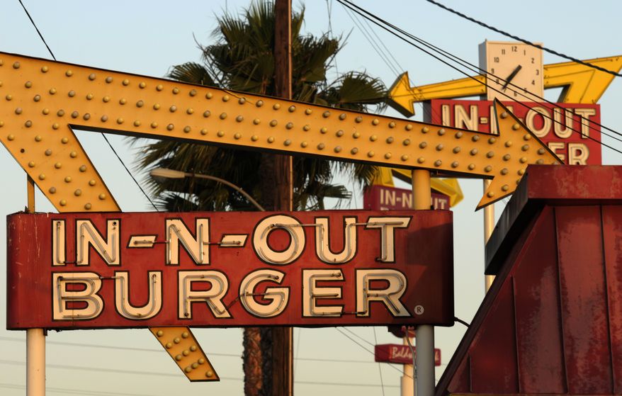 In-N-Out Burger signs, two in the foreground from the fast food chain's original location, and one in the background at a new location across the Interstate 10 freeway, fill the skyline in Baldwin Park, California, June 8, 2010. (AP Photo/Adam Lau) ** FILE **