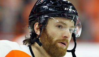 FILE - This is an April 22, 2018, file photo showing Philadelphia Flyers&#39; Sean Couturier during warm-ups before the start of an NHL hockey game in Philadelphia. Couturier is out four weeks after suffering a knee injury for the second time in five months.  General manager Ron Hextall provided the update Wednesday, Aug. 22, 2018, saying Couturier was injured Aug. 10 in an exhibition game. (AP Photo/Tom Mihalek, File)