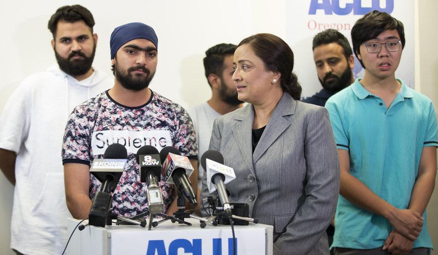 Asylum seeker Lovepreet Singh, who had been detained at the federal prison in Sheridan, Oregon, speaks along with interpreter Navneet Kaur, right, about his experiences in prison and relief at being released at the ACLU office in Portland on Wednesday, Aug. 22, 2018. (Dave Killen/The Oregonian via AP)