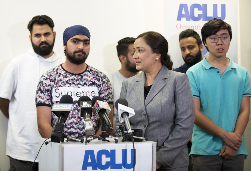 Asylum seeker Lovepreet Singh, who had been detained at the federal prison in Sheridan, Oregon, speaks along with interpreter Navneet Kaur, right, about his experiences in prison and relief at being released at the ACLU office in Portland on Wednesday, Aug. 22, 2018. (Dave Killen/The Oregonian via AP)