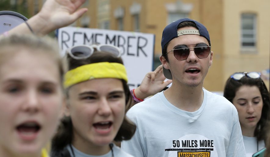 David Hogg, center right, a survivor of the school shooting at Marjory Stoneman Douglas High School, in Parkland, Fla., walks in a planned 50-mile march, Thursday, Aug. 23, 2018, in Worcester, Mass. The march, held to call for gun law reforms, began Thursday, in Worcester, and is scheduled to end Sunday, Aug. 26, 2018, in Springfield, Mass., at the headquarters of gun manufacturer Smith &amp; Wesson. (AP Photo/Steven Senne)