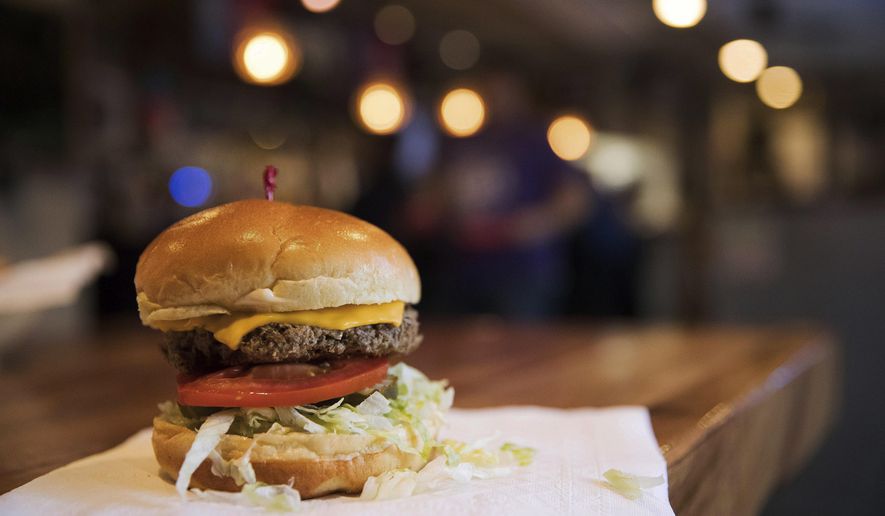 FILE- This Jan 9, 2018, file photo shows the Impossible Burger at Stella's, in Bellevue, Neb., which is a burger is made from plant protein. As companies look to lessen Americans’ reliance on animals for food, the term “plant based” is replacing “vegan” and “vegetarian” because of the unappetizing and polarizing associations the v-words might have. (Ryan Soderlin/The World-Herald via AP, File)