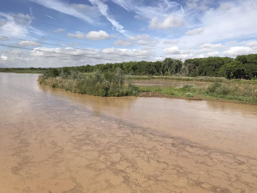 Silt and other debris flow down the Rio Grande following a night of rain in Albuquerque, N.M., on Thursday, Aug. 23, 2018. The Rio Grande's flows have been historically low, prompting the U.S. Bureau of Reclamation to lease water from the Albuquerque Bernalillo County Water Utility Authority to ensure the river does not go dry through the Albuquerque stretch. (AP Photo/Susan Montoya Bryan)