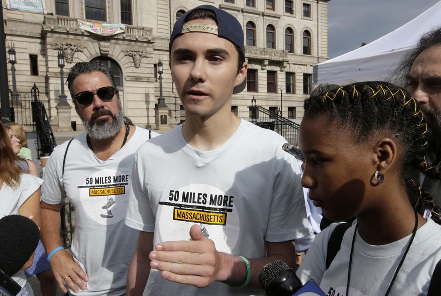 David Hogg, center, a survivor of the school shooting at Marjory Stoneman Douglas High School, in Parkland, Fla., speaks with reporters as Manuel Oliver, left, father of slain Marjory Stoneman Douglas student Joaquin Oliver, and Boston high school student Vikiana Petit-Homme, right, look on before the start of a planned 50-mile march, Thursday, Aug. 23, 2018, in Worcester, Mass. (AP Photo/Steven Senne)