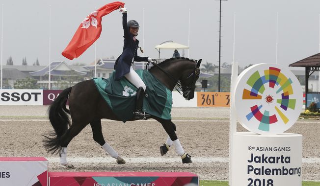 Hong Kong&#x27;s Jacqueline Wing Ying Siu celebrates after winning gold medal during dressage individual intermediate I freestyle equestrian at the 18th Asian Games in Jakarta, Indonesia, Thursday, Aug. 23, 2018. (AP Photo/Achmad Ibrahim)