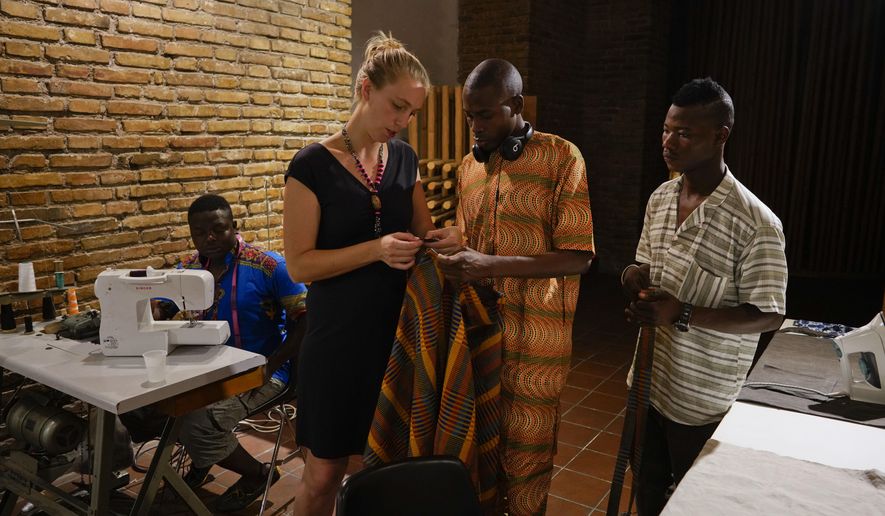 From left, Bakary Bamba, 26, from Ivory Coast, Lydia Witt, 35, from Ohio, Daouda Doumbia, 26, from Ivory Coast and Lassina Coulibaly, 19, from Mali work at The Sewing Cooperative nonprofit organization, in Rome, Monday, Aug. 13, 2018. After a decade working as a dressmaker for the New York City Ballet and Broadway productions, Lydia Witt moved to Rome to channel her passion in a new direction. Last year she started a small organization to employ skilled migrant tailors, mainly from West African countries. (AP Photo/Andrew Medichini)