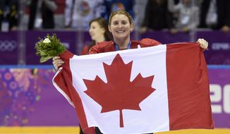 FILE - In this Feb. 21, 2014, file photo, Canada&#39;s Hayley Wickenheiser celebrates with the Canadian flag after beating the USA 3-2 in overtime at the Sochi Winter Olympics in Sochi, Russia. Wickenheiser is the Toronto Maple Leafs new assistant director of player development. (AP Photo/Paul Chiasson, The Canadian Press, File)