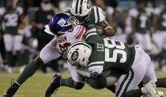 New York Jets linebacker Avery Williamson, top, and linebacker Darron Lee (58) tackle New York Giants tight end Evan Engram (88) who fumbled the ball on the play during the second quarter of an NFL football game, Friday, Aug. 24, 2018, in East Rutherford, N.J. (AP Photo/Julio Cortez)