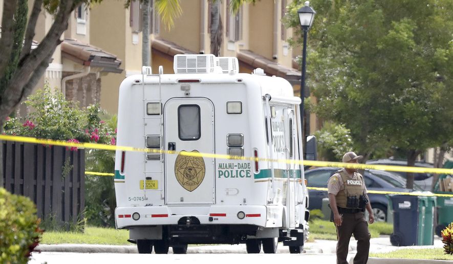 A Miami-Dade police officers patrols after a standoff with a local judge on Friday, Aug. 24, 2018, near Princeton, Fla. Authorities say a Social Security judge shot and killed himself after an hours-long standoff with police at a home southwest of Miami. Police say Timothy Maher, a disability judge at a downtown Miami Social Security Administration office, held three hostages for about 10 hours Friday inside the home. (AP Photo/Brynn Anderson)