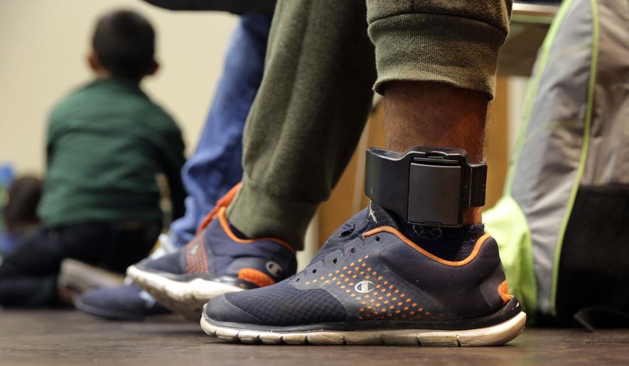 FILE - In this Monday, July 23, 2018 file photo, Carlos Fuentes Maldonado, an immigrant from Honduras seeking asylum who was released and reunited with his family, wears an ankle monitor as he waits at a Catholic Charities facility in San Antonio. Federal authorities’ shift away from separating immigrant families caught in the U.S. illegally now means that many parents and children are quickly released, only to be fitted with electronic monitoring devices _ a practice which both the government and advocacy groups oppose for different reasons. (AP Photo/Eric Gay)