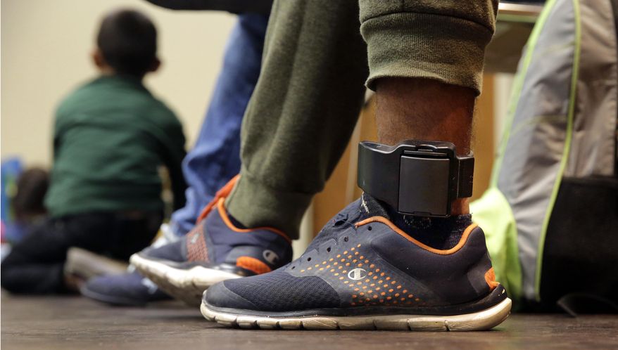 FILE - In this Monday, July 23, 2018 file photo, Carlos Fuentes Maldonado, an immigrant from Honduras seeking asylum who was released and reunited with his family, wears an ankle monitor as he waits at a Catholic Charities facility in San Antonio. Federal authorities’ shift away from separating immigrant families caught in the U.S. illegally now means that many parents and children are quickly released, only to be fitted with electronic monitoring devices _ a practice which both the government and advocacy groups oppose for different reasons. (AP Photo/Eric Gay)