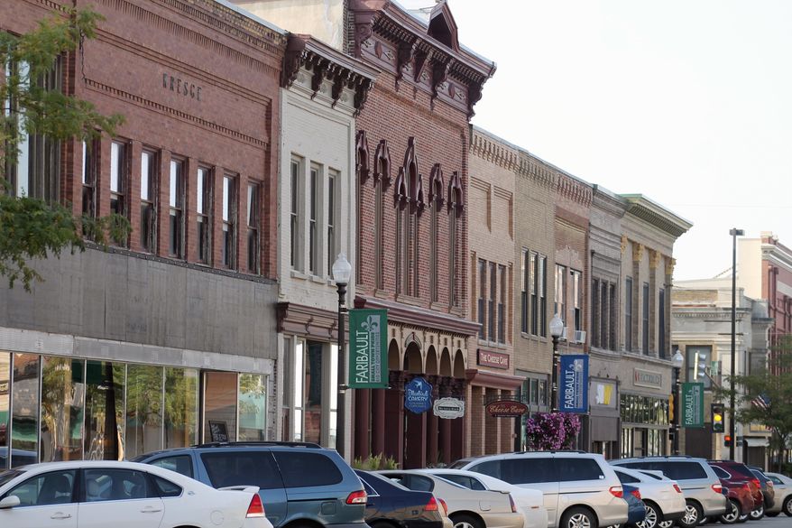In this Aug. 13, 2018, photo provided by MinnPost, cars line a street in downtown Faribault, Minn. Faribault has seen an influx of Somali immigrants in the last three decades. The demographic change initiated by that shift didn't come without consequence, and it is only now, some residents say _ after years of grappling with cultural and racial issues, and overwhelmed schools and social service programs _ that those tensions are starting to fade away, as more and more native-born residents come to terms with the fact that Somali refugees are putting down permanent roots in Faribault. (Ibrahim Hirsi/MinnPost via AP)