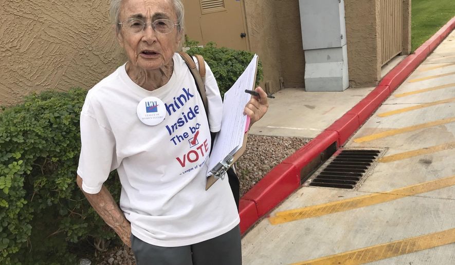 FILE - In this April 19, 2018, file photo, Rivko Knox, of Phoenix, a volunteer with the League of Women Voters, collects signatures for a ballot measure on campaign financing outside a polling station in Glendale, Ariz. A judge on Friday, Aug. 24, upheld a 2016 Arizona law that bans groups from collecting early mail-in ballots from voters and delivering them. The ruling dismissed a legal challenge to the law filed by Knox. (AP Photo/Anita Snow, File)