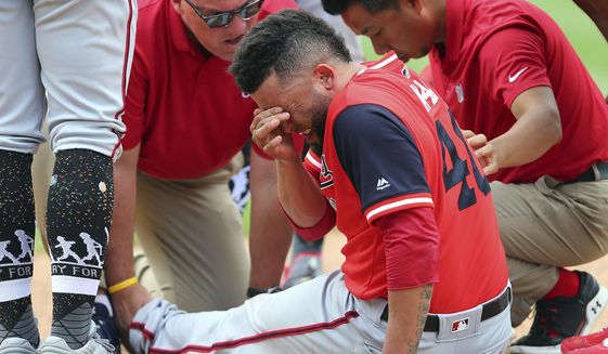 Washington Nationals relief pitcher Kelvin Herrera (40) reacts medical personal look after him after he injured his leg while covering first base on a ground ball hit by New York Mets&#39; Jose Bautista during the ninth inning of a baseball game Sunday, Aug. 26, 2018, in New York. (AP Photo/Rich Schultz)