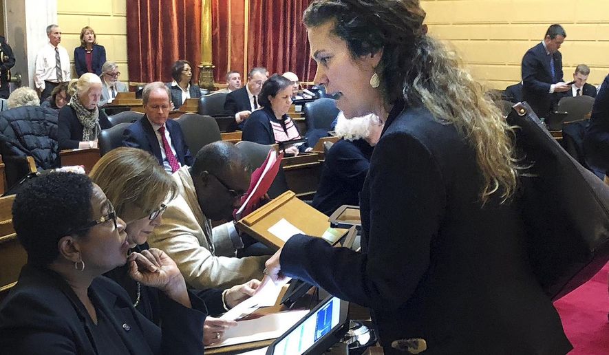 FILE - In this Jan. 9, 2018, file photo, Democratic state Rep. Teresa Tanzi, right, talks with Democratic Rep. Marcia Ranglin-Vassell during a legislative session In Providence, R.I. Tanzi went public with claims she had been sexually harassed, and was appointed to chair a task force that issued recommendations in May on potential changes to state sexual harassment laws. (AP Photo/ Jennifer McDermott, File)