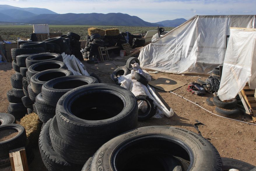 FILE - In this Aug. 10, 2018, file photo, is a makeshift living compound in Amalia, N.M. Prosecutors seeking to keep two men and three women jailed on child-abuse charges in northern New Mexico now say they seized a document entitled "Phases of a Terrorist Attack" at the filthy desert compound where 11 children and a dead boy were found. In a court filing Friday, Aug. 24, 2018, prosecutors said the hand-written document had instructions for "The one-time terrorist" and mentioned an unnamed place called "the ideal attack site." (AP Photo/Morgan Lee, File)