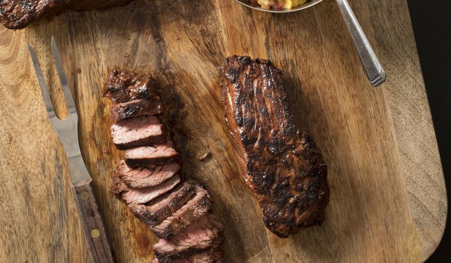 This undated photo provided by America's Test Kitchen in August 2018 shows grilled southwestern steak tips with tangy corn relish in Brookline, Mass. This recipe appears in the cookbook “Just Add Sauce.” (Carl Tremblay/America's Test Kitchen via AP)