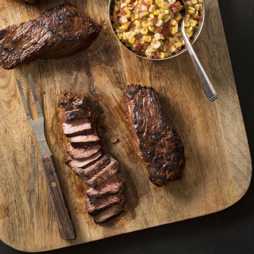This undated photo provided by America's Test Kitchen in August 2018 shows grilled southwestern steak tips with tangy corn relish in Brookline, Mass. This recipe appears in the cookbook “Just Add Sauce.” (Carl Tremblay/America's Test Kitchen via AP)