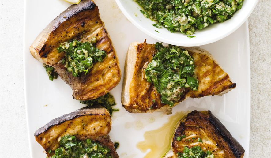 This undated photo provided by America's Test Kitchen in August 2018 shows grilled swordfish steaks with salsa verde in Brookline, Mass. This recipe appears in the cookbook “Master of the Grill.” (Daniel J. van Ackere/America's Test Kitchen via AP)