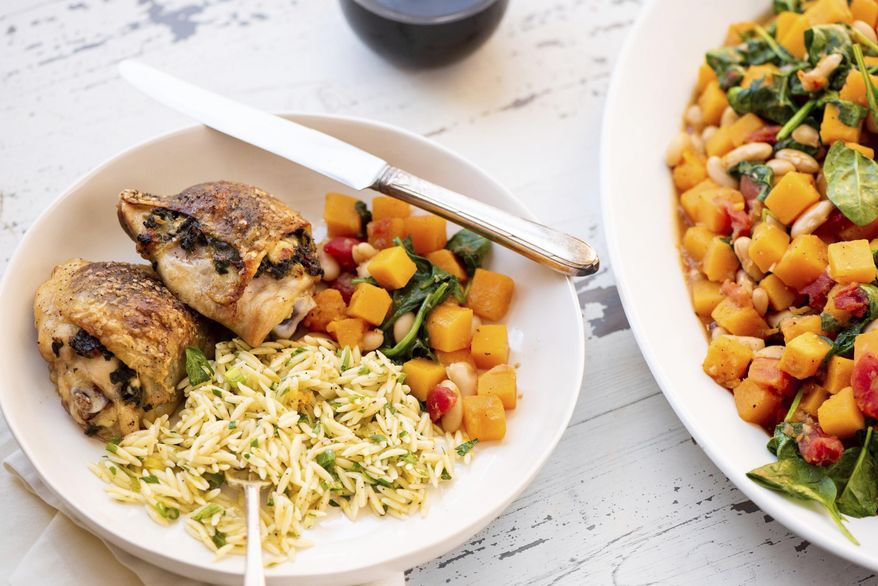 This May 2018 photo shows spinach- and feta-stuffed chicken thighs in New York. This dish is from a recipe by Katie Workman. (Cheyenne Cohen via AP)