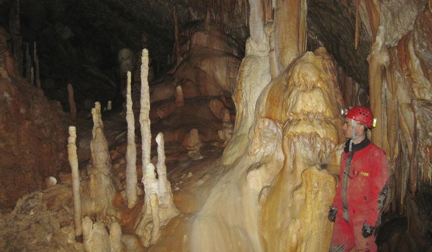 In this 2013 photo provided by Bogdan Onac, researcher Vasile Ersek stands in the Ascunsa Cave in Romania. Scientists say ancient shifts in climate helped our species replace Neanderthals in Europe. Researchers used data from this cave and another to document two lengthy cold and dry periods. The report, released Monday, Aug. 27, 2018, by the Proceedings of the National Academy of Sciences, found these periods coincided with the disappearance of Neanderthals and the arrival of our species in specific places. (Bogdan Onac via AP)