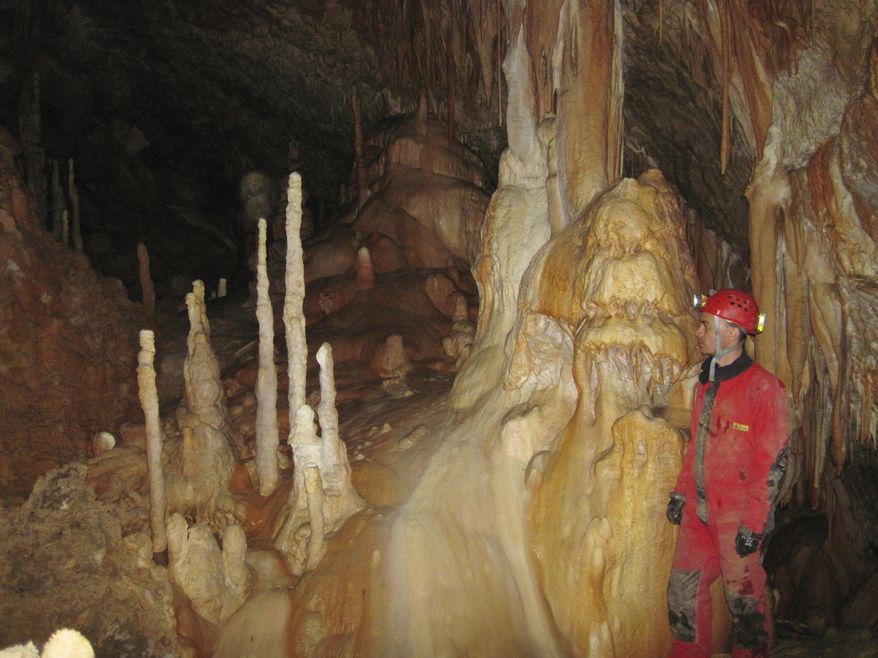 In this 2013 photo provided by Bogdan Onac, researcher Vasile Ersek stands in the Ascunsa Cave in Romania. Scientists say ancient shifts in climate helped our species replace Neanderthals in Europe. Researchers used data from this cave and another to document two lengthy cold and dry periods. The report, released Monday, Aug. 27, 2018, by the Proceedings of the National Academy of Sciences, found these periods coincided with the disappearance of Neanderthals and the arrival of our species in specific places. (Bogdan Onac via AP)