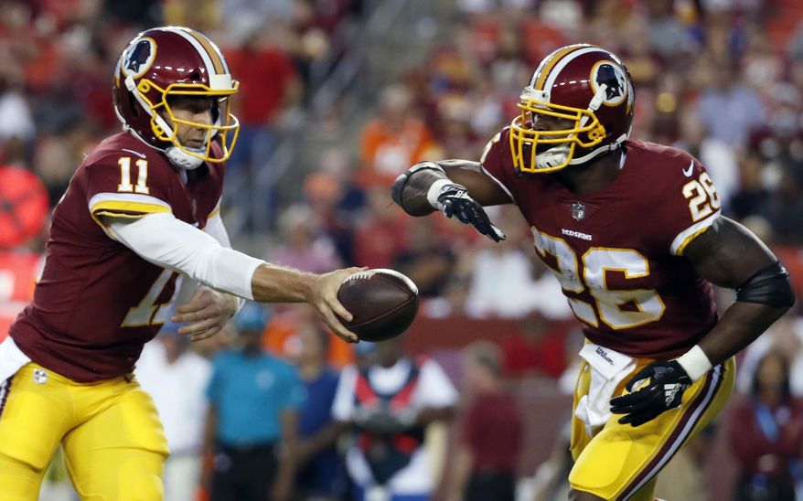 FILE - In this Aug. 24, 2018, file photo, Washington Redskins quarterback Alex Smith (11) hands the ball off to running back Adrian Peterson during the first half of a preseason NFL football game against the Denver Broncos in Landover, Md. The Redskins acquired Smith, a winner wherever he's played, after last season. Peterson has a shot to be a featured back once again. (AP Photo/Alex Brandon, File) **FILE**