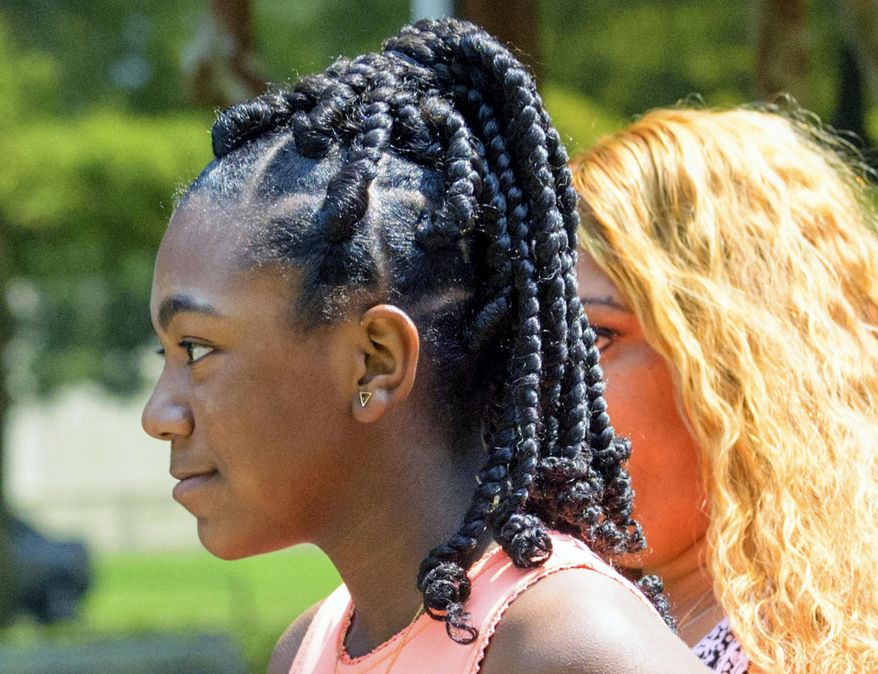 FILE - In this Friday, Aug. 24, 2018, file photo, Faith Fennidy walks to a news conference outside the offices of attorney James Williams, in Metairie, La. A Catholic school official says a suburban New Orleans school has rescinded its policy forbidding hair extensions. But it remains unclear whether Fennidy, a sixth-grader who left the school in tears a week earlier after running afoul of the rule, will return to Christ the King school. (Matthew Hinton/The Advocate via AP, File)