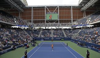 Evgeniya Rodina, of Russia, foreground, and Sloane Stephens warm-up to play in Louis Armstrong Stadium during the first round of the U.S. Open tennis tournament, Monday, Aug. 27, 2018, in New York. (AP Photo/Julio Cortez)