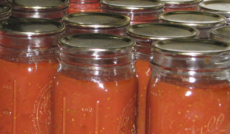 This undated photo shows canned tomatoes in jars in New Paltz, N.Y. A pot of tomatoes, cooked down, blended, and then canned, brings some summer-y flavor to the dead of winter. (Lee Reich via AP)