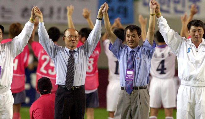 FILE - In this Saturday, Sept. 7, 2002 file photo, South Korean national soccer team&#x27;s head coach Park Hang-seo, second from left, and North Korean head coach Ri Jung-man, second from right, with the two team&#x27;s players, raise their hands to South Korean soccer fans after their friendly match for unification of both Koreas, at the Sangam World Cup Stadium in Seoul, South Korea. If South Korea&#x27;s national team is to reach the final of the Asian Games and win an exemption from military service for its players, then it will have to get past Vietnam and the &amp;quot;Korean Hiddink.&amp;quot; Korean coach Park Hang-seo, a member of Guus Hiddink&#x27;s coaching staff at the 2002 World Cup when South Korea reached the semifinals, is coaching Vietnam. (AP Photo/ Yun Jai-hyoung)