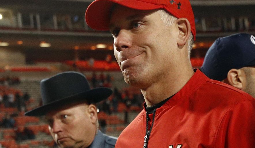 FILE - In this Nov. 25, 2017, file photo, Maryland head coach DJ Durkin walks off the field after an NCAA college football game against Penn State, in College Park, Md. As interim coach of the Maryland football team, Matt Canada is preparing the squad ready for Saturday’s opener against No. 23 Texas, fulfilling his duties as offensive coordinator and, most importantly, making sure to keep the players focused in a season dedicated to fallen teammate Jordan McNair. McNair, a sophomore offensive lineman, died on June 13, two weeks after collapsing during a team workout. Since that time, Maryland has launched two investigations _ one to unearth the circumstances surrounding McNair’s death, the other to address allegations of an abusive culture within the program. Head coach Durkin was placed on administrative leave on Aug. 11, leaving Canada in charge of a team with no shortage of distractions. (AP Photo/Patrick Semansky, File)