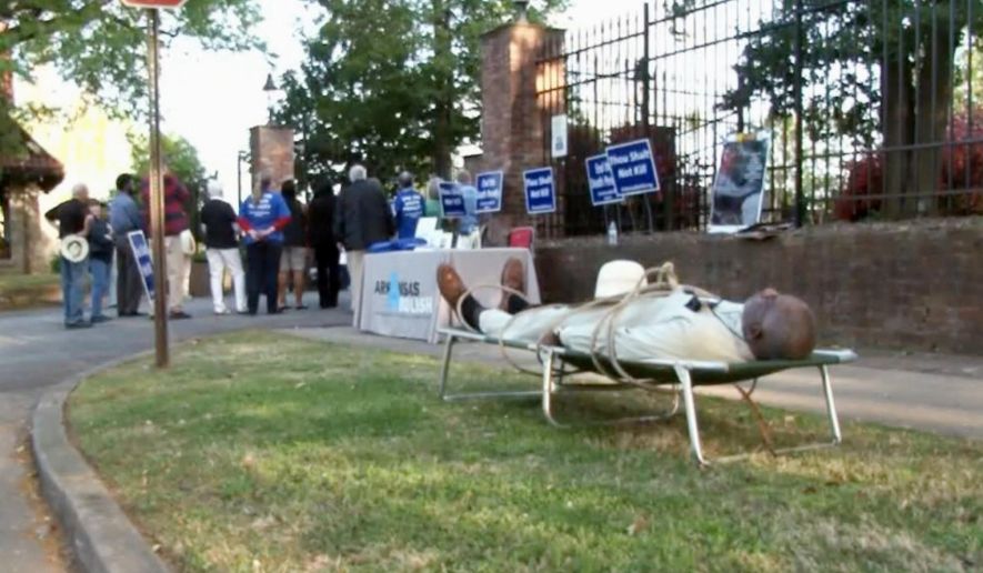 FILE - In this Tuesday, April 17, 2018, file image from video provided by KTHV-TV, Pulaski County Circuit Judge Wendell Griffen lies on a cot outside the Arkansas governor's mansion in Little Rock during a death penalty protest. A federal appeals court on Wednesday, Aug. 29, 2018, says it won't revive Griffen's lawsuit challenging his disqualification from execution cases over his participation in an anti-death penalty demonstration last year.  (KTHV/TEGNA Inc. via AP, File)