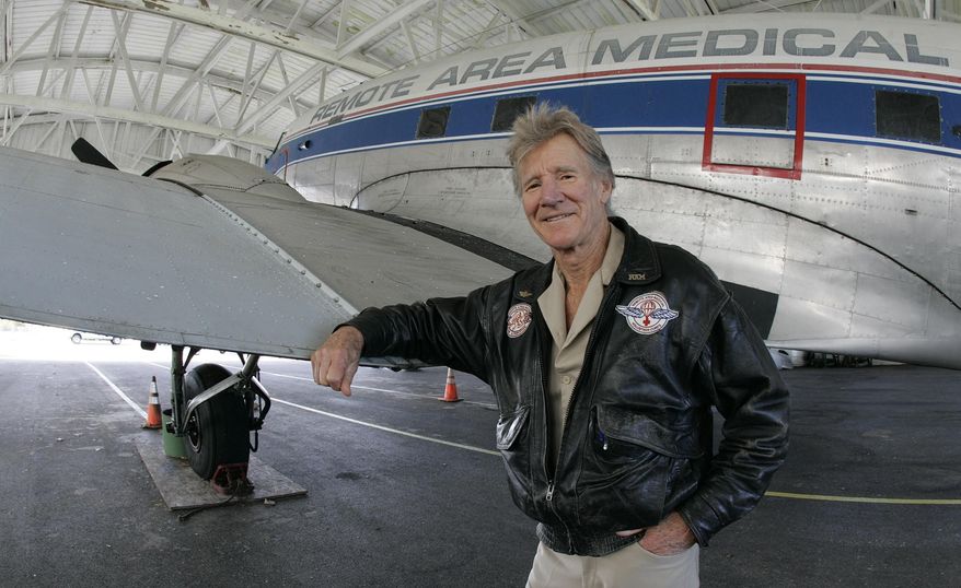 FILE - This Nov. 13, 2009, file photo shows Remote Area Medical director Stan Brock, standing with a 1944 DC3 airplane in Knoxville, Tenn. Brock, the founder of an organization that uses mobile medical clinics to bring health care services to people in remote, underserved areas of the U.S. and around the world, died in Tennessee on Wednesday, Aug. 29, 2018, Remote Area Medical says in a news release. He was 82. (AP Photo/Wade Payne, File)