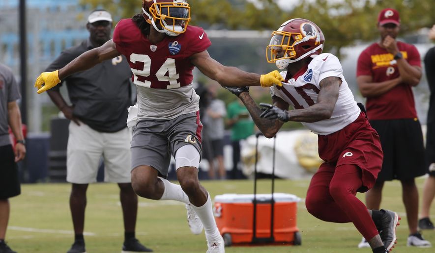File- This July 31, 2018, file photo shows Washington Redskins defensive back Josh Norman (24) covering wide receiver Paul Richardson (10) during the morning session at NFL football training camp in Richmond, Va. Norman is going into the third year of a $75 million contract with just three interceptions for the Redskins and none last season. His abilities as a cover cornerback are unquestioned and mean he gets fewer opportunities, but Norman also dropped a handful of potential interceptions in 2017 and is being counted on, and paid, to make that kind of a difference in a young secondary. (AP Photo/Steve Helber, File)