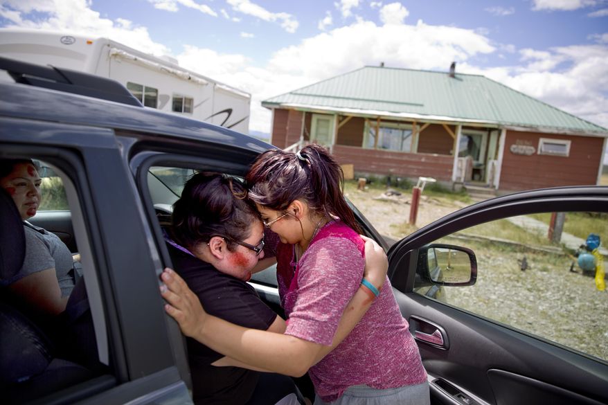 ADVANCE FOR USE WEDNESDAY, SEPT. 5, 2018 AND THEREAFTER-Kimberly Loring, left, touches her forehead to her little sister, Jonnilyn, 17, as she says goodbye before heading out on a search for their missing sister Ashley with their cousin, Lissa Loring, left, outside their home on the Blackfeet Indian Reservation in Browning, Mont., Wednesday, July 11, 2018. "I'm the older sister. I need to do this," says 24-year-old Kimberly. "I don't want to search until I'm 80. But if I have to, I will." (AP Photo/David Goldman)