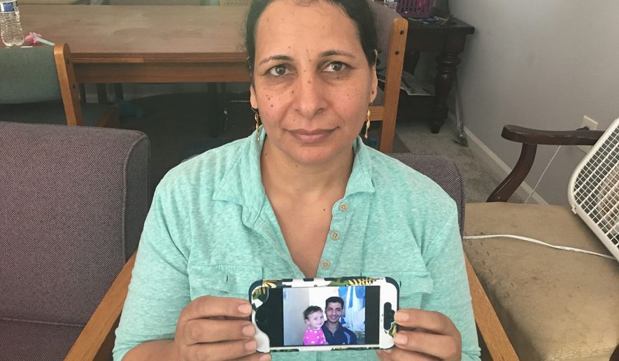 Fayza Estephanos keeps a photo of her brother Samuel with her infant daughter. Samuel, along with their brother Beshoy, were kidnapped in Libya and beheaded by Islamic State militants in February 2014 for refusing to renounce their Christianity. (Photograph by Laura Kelly/The Washington Times)