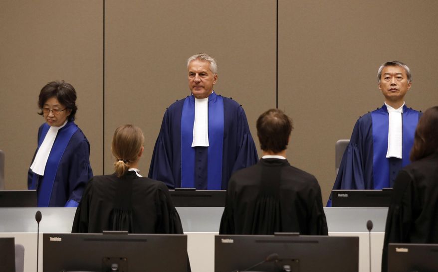Presiding Judge Robert Fremr, center, stands in the courtroom of the International Criminal Court (ICC) during the closing statements of the trial of Bosco Ntaganda, a Congo militia leader, in The Hague, Netherlands, Tuesday Aug. 28, 2018. Ntaganda is facing charges of war crimes and crimes against humanity allegedly committed in the eastern Ituri region of Congo from 2002-2003. (Bas Czerwinski/Pool via AP) ** FILE **