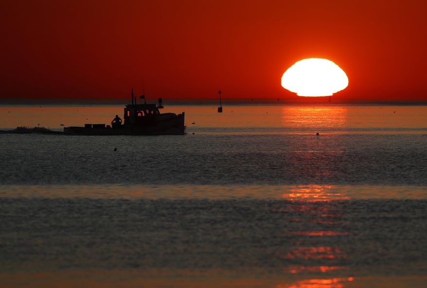 FILE - In this Sept. 13, 2017, file photo, a lobster fishing boat heads out to sea at sunrise off shore from Portland, Maine. New 2018 data indicates that the Gulf of Maine, one of the fastest warming bodies of water in the world, is in the midst of an all-time hot stretch. (AP Photo/Robert F. Bukaty, File)