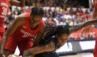 Washington Mystics guard Ariel Atkins, left, battles for the ball against Atlanta Dream forward Jessica Breland, right, during the first half of Game 3 of a WNBA basketball playoffs semifinal Friday, Aug. 31, 2018, in Washington. (AP Photo/Nick Wass) ** FILE **