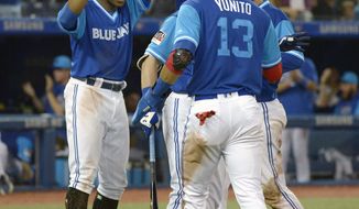 Toronto Blue Jays&#39; Curtis Granderson, left to right, Lourdes Gurriel Jr and Danny Jansen celebrate teammate Aledmys Diaz&#39;s three run double against the Philadelphia Phillies during the eighth inning of a baseball game, Saturday, Aug. 25, 2018 in Toronto. (Jon Blacker/The Canadian Press via AP)