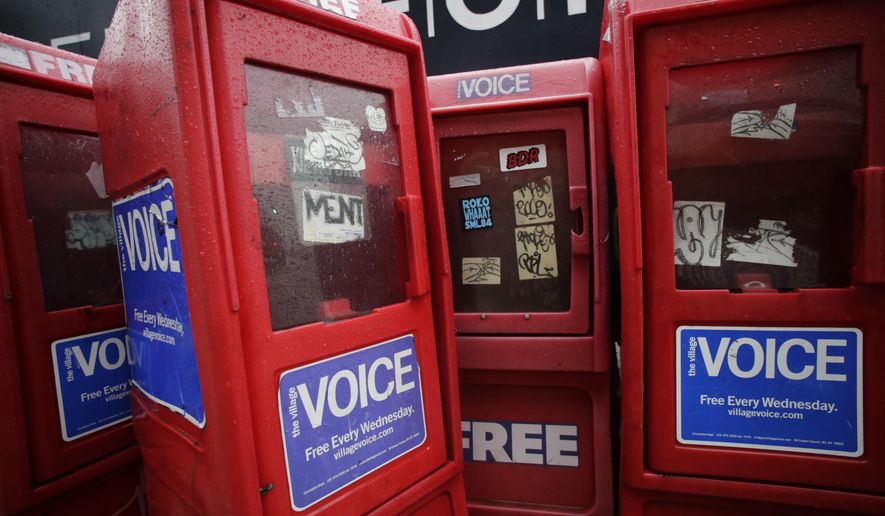 In this Nov. 27, 2013 photo, plastic newspaper boxes for The Village Voice stand along a Manhattan sidewalk in New York. Village Voice publisher Peter Barbey announced on Friday, Aug. 31, 2018, that the venerable alternative weekly will cease publication. The announcement comes three years after Barbey bought the paper and one year after it ceased publishing in print. (AP Photo/Mark Lennihan)
