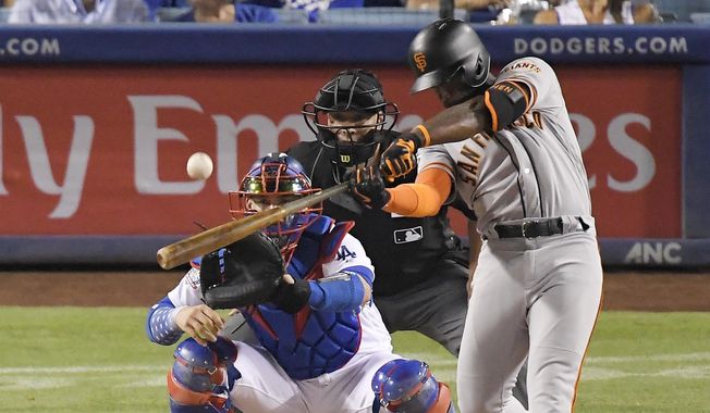 FILE - In this Aug. 15, 2018, file photo, San Francisco Giants&#x27; Andrew McCutchen hits a three-run home run as Los Angeles Dodgers catcher Yasmani Grandal and home plate umpire Stu Scheurwater watch during the eighth inning of a baseball game in Los Angeles. The playoff-contending New York Yankees are close to completing a trade for San Francisco Giants outfielder Andrew McCutchen. A person familiar with the negotiations told The Associated Press on Thursday night, Aug. 30, 2018,  the Yankees would send infielder Abiatal Avelino and another minor leaguer to San Francisco for McCutchen. The person spoke on condition of anonymity because the deal wasn&#x27;t finalized. (AP Photo/Mark J. Terrill, File)