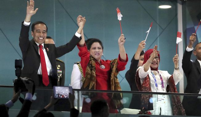 FILE - In this Aug. 18, 2018, file photo, Indonesian President Joko Widodo, left, and his wife Iriana wave during the opening ceremony for the 18th Asian Games in the Gelora Bung Karno Stadium, Jakarta, Indonesia. Indonesia&#x27;s hosting of the Asian Games and a record haul of gold medals has swelled national pride, providing a boost to the re-election campaign of President Joko &amp;quot;Jokowi&amp;quot; Widodo. (AP Photo/Dita Alangakara, File)