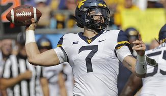 West Virginia&#39;s Will Grier (7) looks to pass against Tennessee in the first half of an NCAA college football game in Charlotte, N.C., Saturday, Sept. 1, 2018. (AP Photo/Chuck Burton)