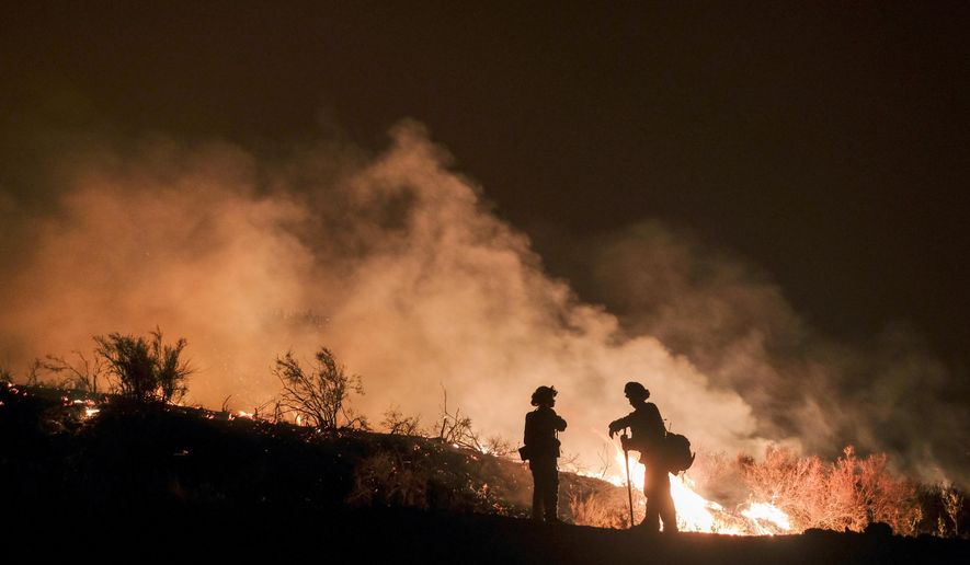 File - In this Aug. 9, 2018, file photo, firefighters keep watch the Holy Fire burning in the Cleveland National Forest in Lake Elsinore, Calif. Researchers have expanded a health-monitoring study of wildland firefighters after a previous study found season-long health declines and deteriorating reaction times. (AP Photo/Ringo H.W. Chiu, File)