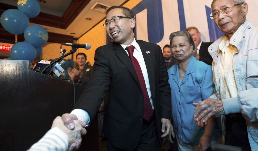 FILE - In this Sept. 9, 2014, file photo, Rhode Island Republican gubernatorial nominee Allan Fung shakes hands with a supporter as his mother, Tan Ping Fung, center, and father, Kwong Wen Fung, right, watch during a primary election night watch party in Warwick, R.I. Fung is seeking the Republican nomination in the Sept. 12, 2018 primary, to again run for governor. (AP Photo/Gretchen Ertl, File)