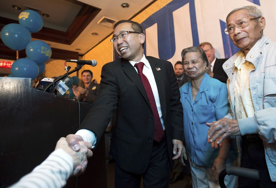 FILE - In this Sept. 9, 2014, file photo, Rhode Island Republican gubernatorial nominee Allan Fung shakes hands with a supporter as his mother, Tan Ping Fung, center, and father, Kwong Wen Fung, right, watch during a primary election night watch party in Warwick, R.I. Fung is seeking the Republican nomination in the Sept. 12, 2018 primary, to again run for governor. (AP Photo/Gretchen Ertl, File)