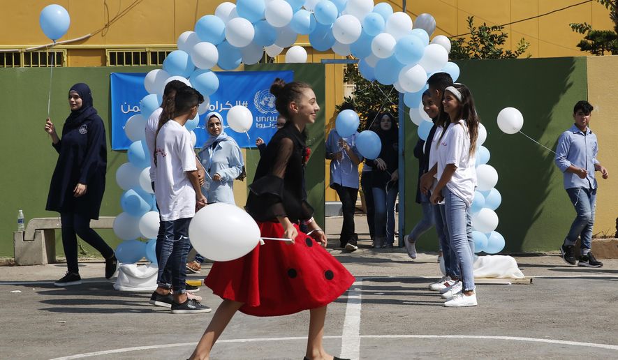 Palestinian refugee students attend a ceremony to mark the return to school of a new year at one of the UNRWA schools, in Beirut, Lebanon, Monday, Sept. 3, 2018. The United Nations' Palestinian relief agency celebrated the start of the school year in Lebanon on Monday, managing to open its schools on schedule despite a multi-million dollar budget cut on the heels of U.S. President Donald Trump's decision to stop funding to the agency. (AP Photo/Hussein Malla)